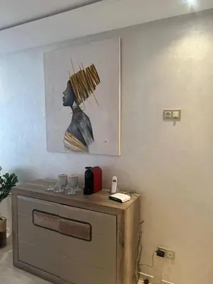 a wall with a painting of a woman with a umbrella at APPARTEMENT CARRE EDEN in Marrakech