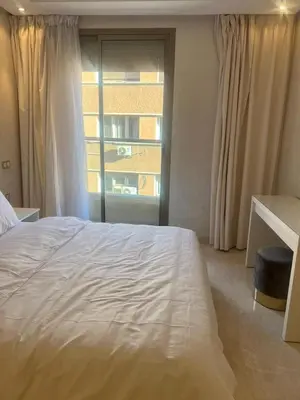 a bedroom with a large white bed and a window at APPARTEMENT CARRE EDEN in Marrakech