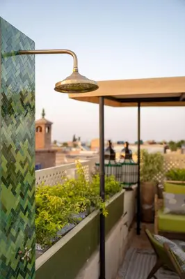 a lamp on top of a balcony with plants at Riad Dar Labzar in Marrakech