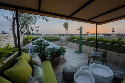 a patio with tables and chairs on a balcony at Riad Dar Labzar in Marrakech