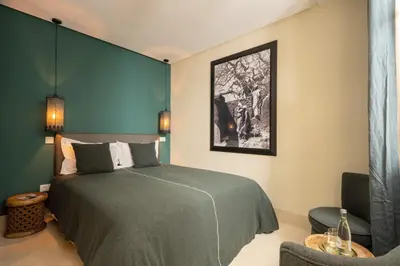 a bedroom with a bed and a black and white picture at Riad Dar Labzar in Marrakech