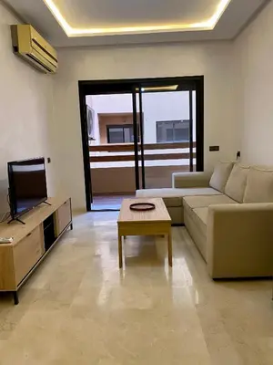 a living room with a couch and a tv and a table at Appartement 2 chambres salon centre de Gueliz 19 in Marrakech