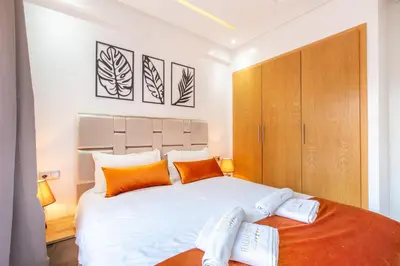a bedroom with a large white bed with orange pillows at New! Appartemant au millieu de guéliz in Marrakech