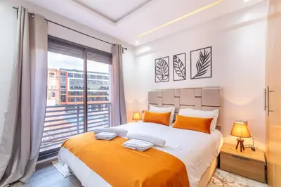 a bedroom with a large bed and a large window at New! Appartemant au millieu de guéliz in Marrakech
