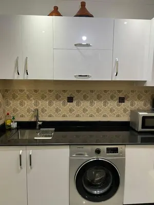 a kitchen with white cabinets and a washing machine at La koutoubia in Marrakech