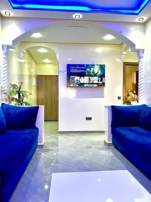 a lobby with two blue couches and a tv at La koutoubia in Marrakech