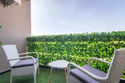a patio with chairs and a table and a hedge at NEW! Gueliz,Terrasse, Fibre optique, IPTV in Marrakech