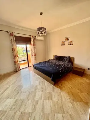 a bedroom with a bed and a wooden floor at Appartement les résidences du rêve in Marrakech