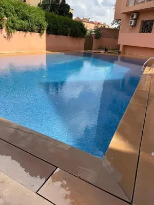 a swimming pool in a building with blue water at Appartement les résidences du rêve in Marrakech