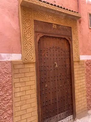 a wooden door with the number on a building at Maison 211 in Marrakech