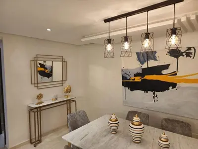 a dining room with a table and a painting on the wall at Luxury Modern Apartment in the heart of Marrakesh. in Marrakech