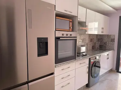 a kitchen with a refrigerator and a washer and dryer at Luxury Modern Apartment in the heart of Marrakesh. in Marrakech
