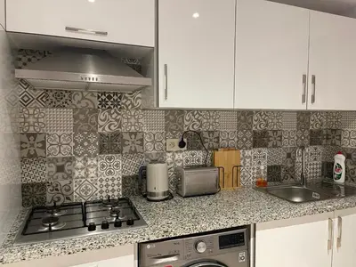 a kitchen with white cabinets and a stove top oven at Luxury Modern Apartment in the heart of Marrakesh. in Marrakech