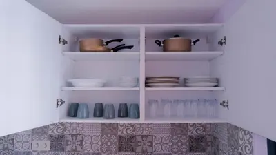 a kitchen with white shelves with bowls and plates at Luxury Modern Apartment in the heart of Marrakesh. in Marrakech