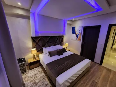 a bedroom with a large bed with purple lighting at Luxury Modern Apartment in the heart of Marrakesh. in Marrakech