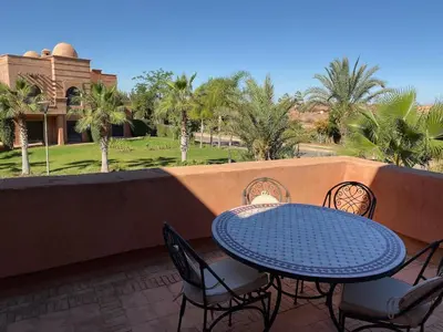 a blue table and chairs on a balcony with palm trees at atlas golf resort marrakech 