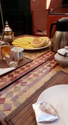 a table with a table with a pizza on it at Riad La Perle de Marrakech in Marrakech