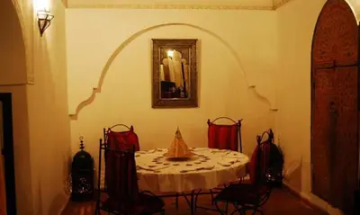 a dining room with a table and a mirror at Riad La Perle de Marrakech in Marrakech