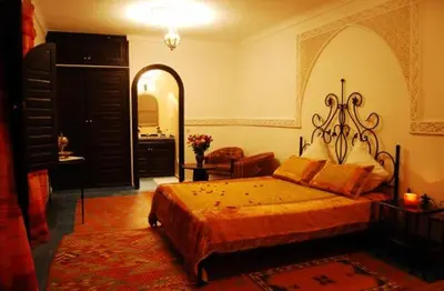 a bedroom with a large bed and a mirror at Riad La Perle de Marrakech in Marrakech