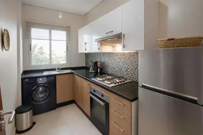 a kitchen with a washer and dryer in it at Prestigia Marrakech Dar Cheryana in Marrakech