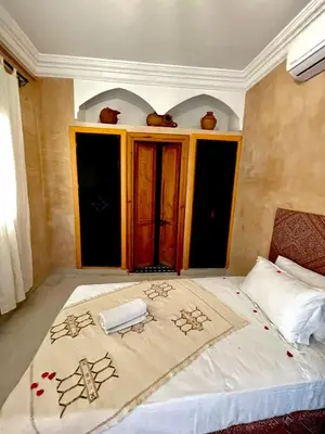 a bedroom with a bed with a blanket with flowers on it at Riad Les Miroirs in Marrakech
