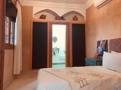 a bedroom with a bed and a large window at Riad Les Miroirs in Marrakech