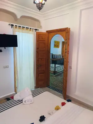a bedroom with a bed and an open door at Riad Les Miroirs in Marrakech