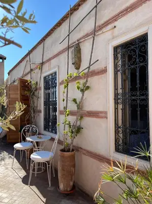 a patio with chairs and a table and a building at Riad Al Massarah in Marrakech
