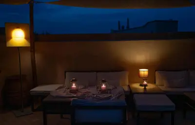 a room with a table and two chairs and lights at Riad Al Massarah in Marrakech