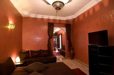 a living room with a couch and a flat screen tv at RIAD Le MINASDAM in Marrakech