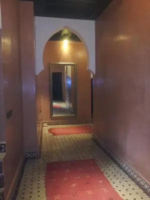a hallway with a mirror and a red rug at RIAD Le MINASDAM in Marrakech