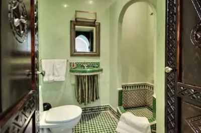 a bathroom with a toilet and a mirror at RIAD Le MINASDAM in Marrakech