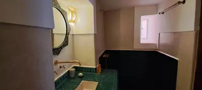 a bathroom with a green sink and a mirror at Riad Parfum d'Orient in Marrakech