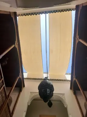 a room with two windows with curtains and a clock at Riad Parfum d'Orient in Marrakech