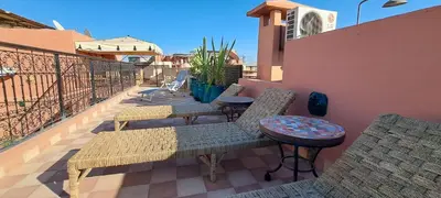 a group of chairs and tables on a balcony at Riad Parfum d'Orient in Marrakech