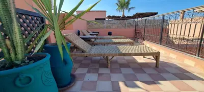 a patio with two benches and potted plants on a balcony at Riad Parfum d'Orient in Marrakech