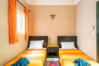 two beds sitting next to each other in a room at Riad Anir in Marrakech