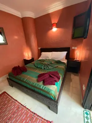 a bedroom with a bed with red walls at Riad Anir in Marrakech
