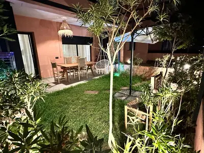 a garden with a table and chairs in a house at LDM Appartements Marrakech in Marrakech