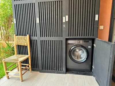 a washing machine and a chair in front of a wall at LDM Appartements Marrakech in Marrakech
