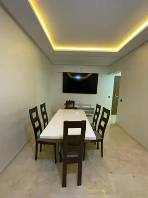 a dining room with a white table and chairs at Best Appartement 3 BEDROOMS in Marrakech