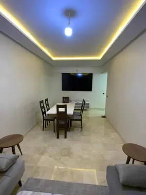 a living room with a table and chairs and a projection screen at Best Appartement 3 BEDROOMS in Marrakech