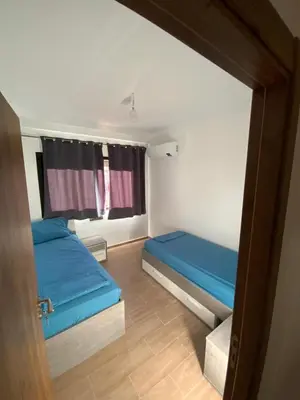 a small room with two beds and a window at Best Appartement 3 BEDROOMS in Marrakech
