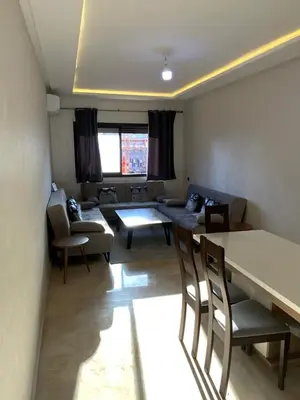 a living room with a couch and a table and chairs at Best Appartement 3 BEDROOMS in Marrakech