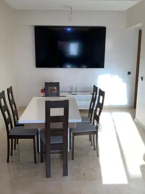 a dining room with a table and chairs and a tv at Best Appartement 3 BEDROOMS in Marrakech