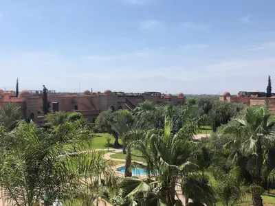 a view of a resort with palm trees and a pool at Chez balqis atlas golf in Marrakech