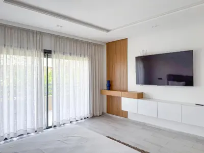 a living room with a tv and a large window at Villa piscine privée, Détente familiale Marrakech in Marrakech