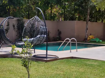 a basket swing in front of a swimming pool at Villa piscine privée, Détente familiale Marrakech in Marrakech