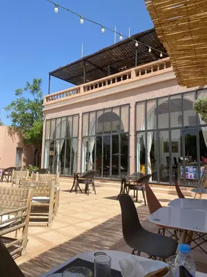 a patio with tables and chairs in front of a building at The BIRD in Marrakech