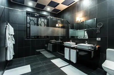 a black bathroom with two sinks and a mirror at The BIRD in Marrakech